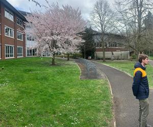 Dr Chris Wyver in front of a cherry tree outside the University of Reading's Agriculture building